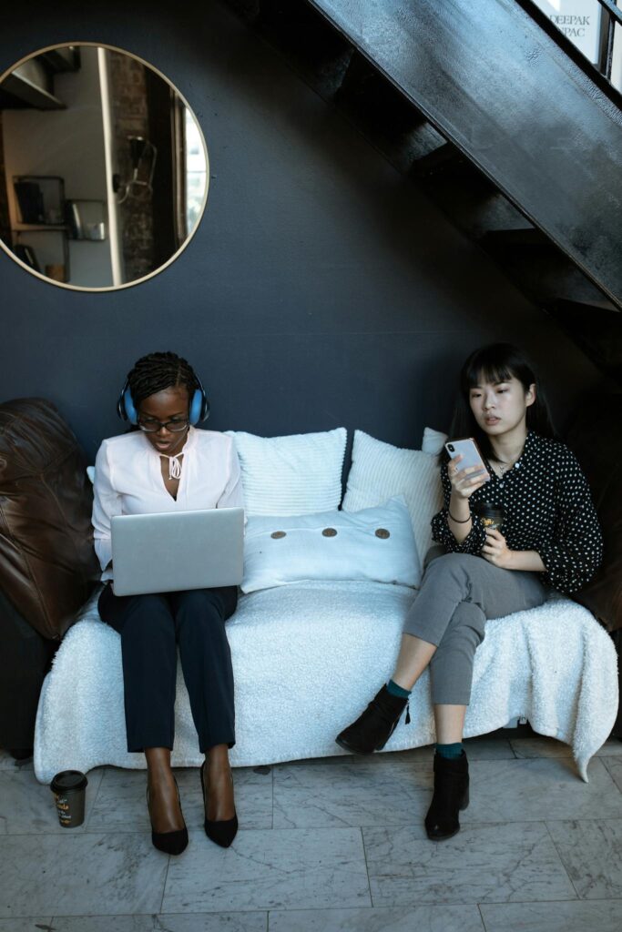 Two women working in a contemporary coworking space, highlighting diversity and productivity.